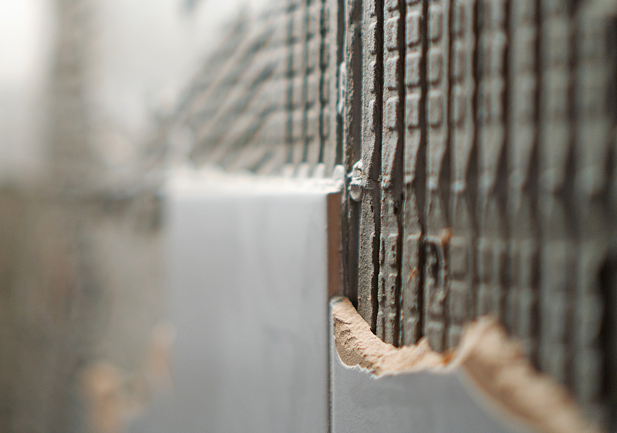 Rikkinäinen laatoitettu seinä kylpyhuoneessa.