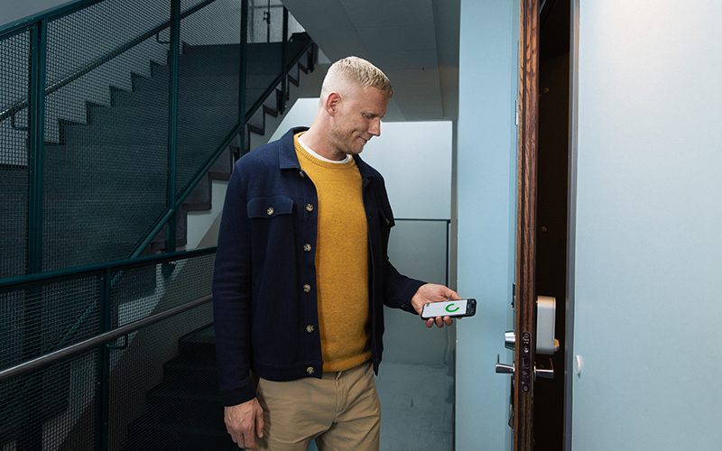 Mies avaa älylukollista ovea