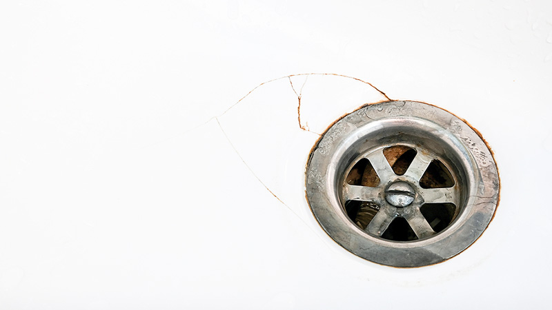 Halkeamia käsienpesualtaassa viemärin vieressä